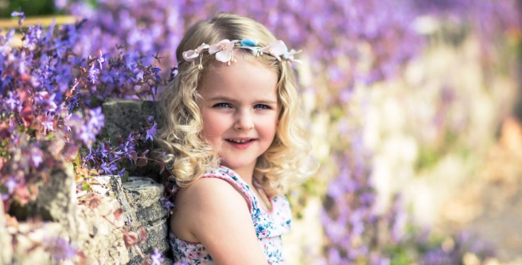 Girl in purple flower field by family photographer in Poole Iryna Photography